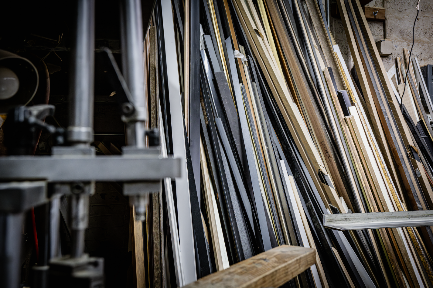 Various picture frame moldings leaning in workshop storage area